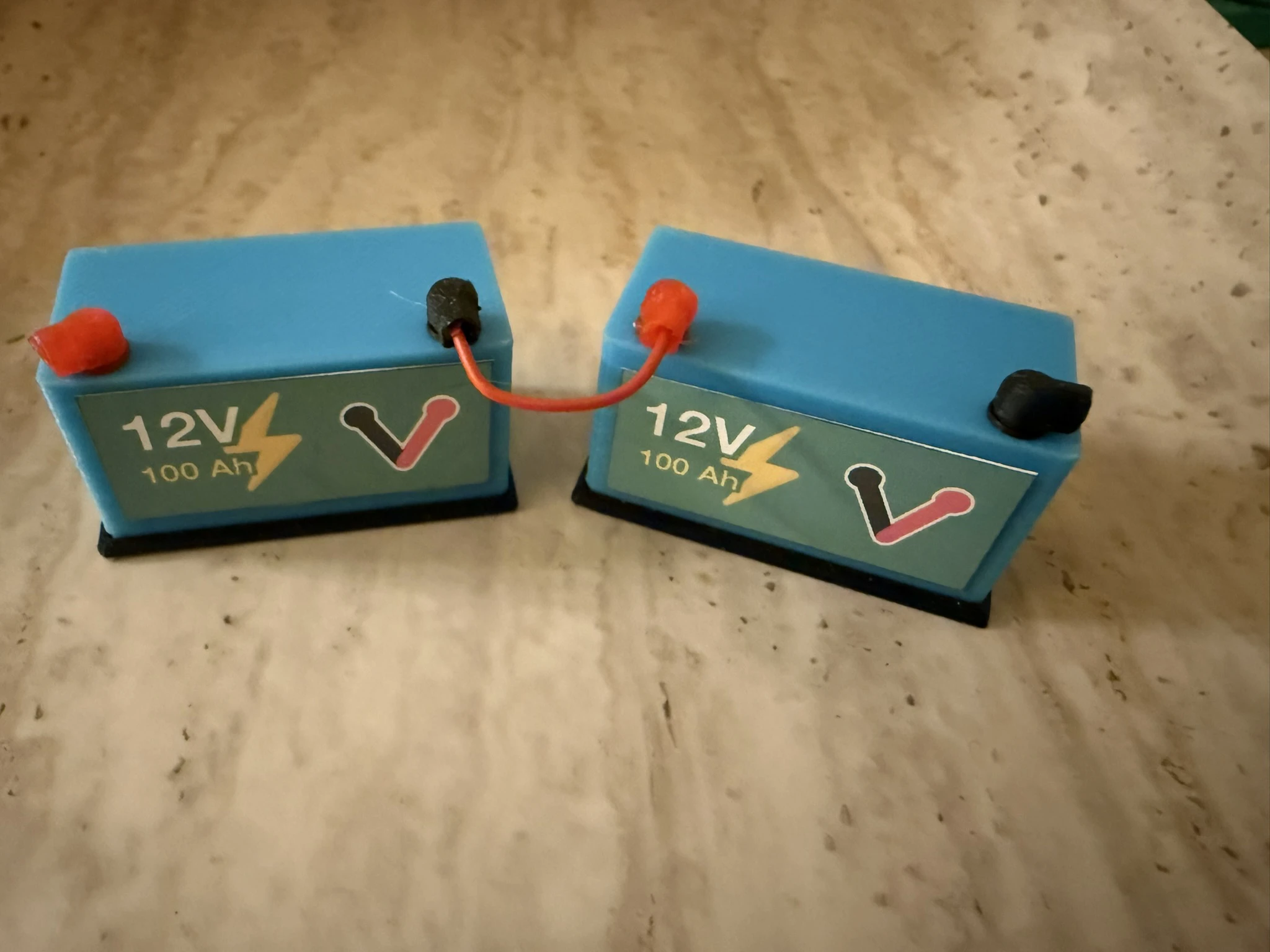 Miniature: Two 12V batteries connected in series, with positive of first battery to negative of second battery, showing 24V output with same amp hours as single battery